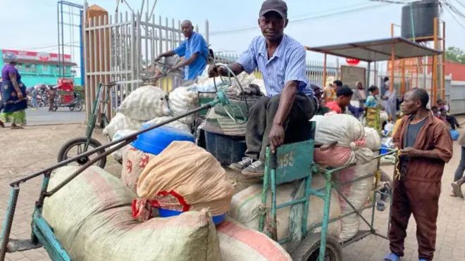 Musa Waseme yicaye ku igare ritwara ibicuruzwa agiye kugurisha hakurya i Goma