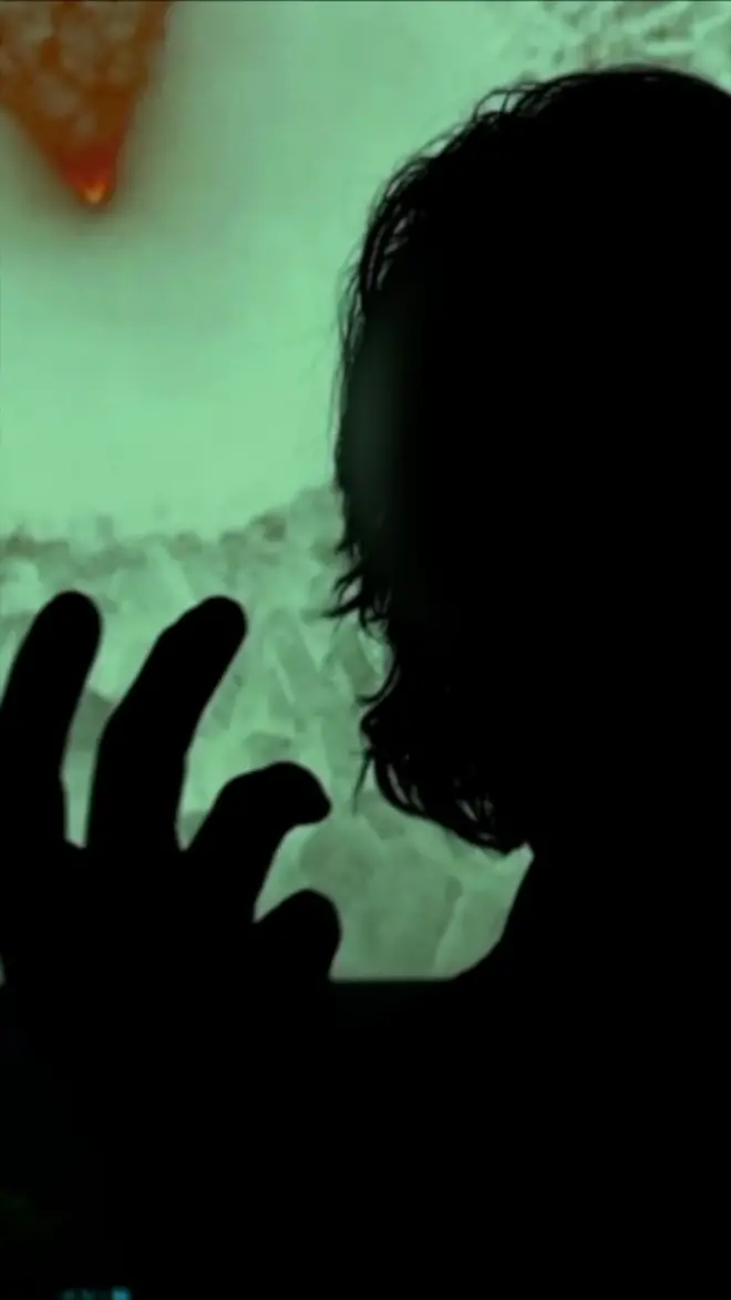 silueta osobe koja govori u mraku iza zelena pozadina