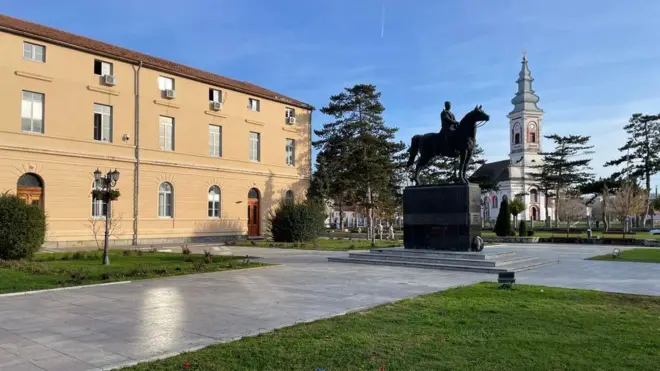 Spomenik Živojina Mišića u centru Mionice, u dalji se nazire crkva