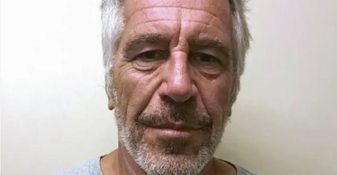 Foto de Jeffrey Epstein olhando fixamente para a câmera, com barba por fazer, diante de uma parede. 