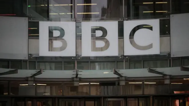 ロンドンのBBC本社の入り口。ガラス張りのビルの表面に「BBC」とロゴが掲げられている