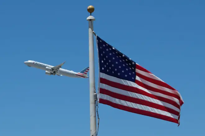 Bandeira dos EUA com avião ao fundo