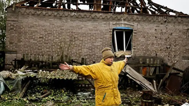  Một phụ nữ nói chuyện với phóng viên tại làng Kramatorsk, vùng Donetsk, Ukraine vào ngày 4/10, phía sau là ngôi nhà bị phá hủy sau đợt tấn công bằng tên lửa của Nga