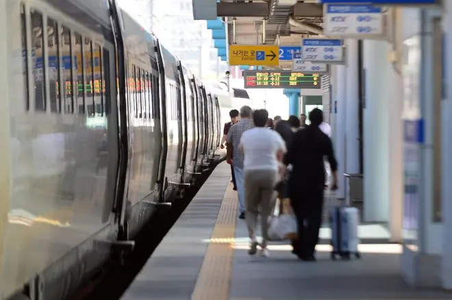 기차를 타기 위해 플랫폼을 걸어가는 사람들