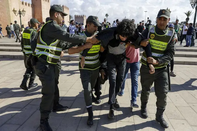 الشرطة المغربية تعتقل أحد المتظاهرين قرب مبنى البرلمان في الرباط.