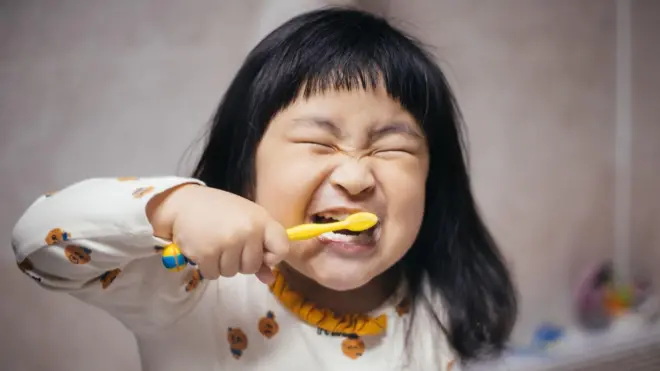 فتاة صغيرة تنظف أسنانها