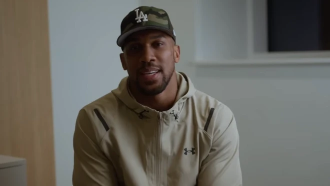 Anthony Joshua sits in front of a camera for a Youtube video 