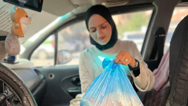 شابة تحمل كيساً من الخبز