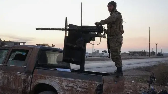 یک نیروی نظامی پشت خودرویی که تیربار بزرگی دارد ایستاده است