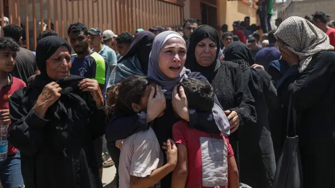 فلسطينية تحضن طفلين بعد غارة إسرائيلية على منطقة المواصي في 13 يوليو/ تموز 2024