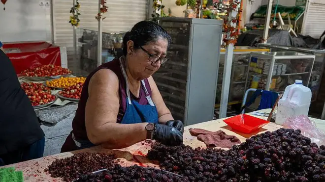 Una vendedora recoge moras en el mercado de alimentos de la Alameda.