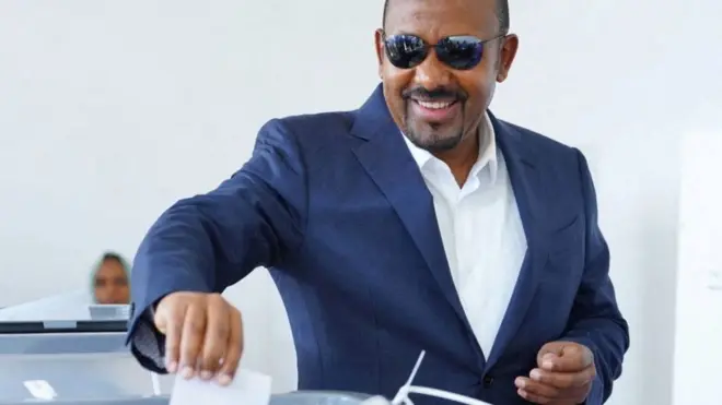 ዐቢይ ጥቁር መነጽር አድርገው የድምጽ መስጫ ካርዳቸውን ሳጥን ውስጥ ሲያስገቡ  