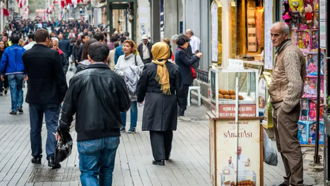 Taksim İstiklal Caddesi'nin kalabalık halinden bir görüntü. Yanda bir simir satıcısı görünüyor