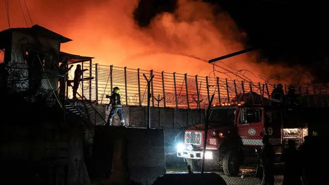 Vurulan hastaneden alevler yükseliyor, itfaiye erleri müdahale etmeye çalışıyor.
