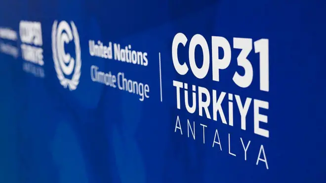 Mavi duvarda yakından uzağa COP31 Türkiye Antalya United Nations Climate Change yazıları var. 