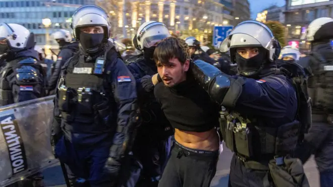 полицајци у пуној опреми држе младића 