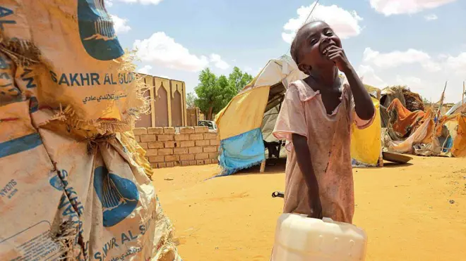 فتاة سودانية تتفاعل وهي تحمل عبوة بلاستيكية في مخيم الرحمانية للنازحين، بالقرب من مدينة الأبيّض في منطقة كردفان الجنوبية