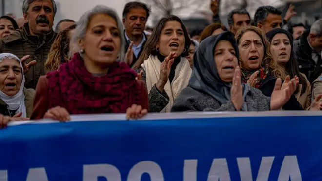 DEM Parti Milletvekili Ceylan Akça Çupolo protesto sırasında sloganlar atıyor. Önünde Rojava yazılı pankart ve yanında başka kadınlar var. Diyarbakır'da binlerce kişi, Suriye ordusunun düzenlediği saldırıları protesto etti.