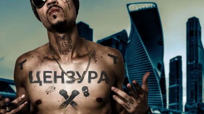 Коллаж: полуобнаженный рэпер в темных очках, в татуировках и с крупными буквами ЦЕНЗУРА на груди на фоне небоскребов