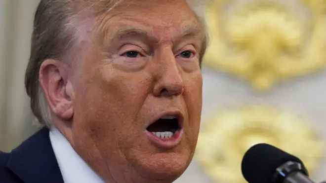 Trump speaks into a mic in the White House.