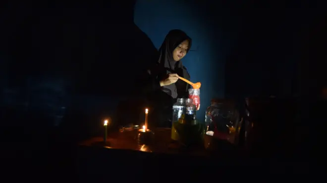 Pedagang menyiapkan minuman untuk pembeli saat pemadaman listrik di Nagari Kasang, Padang Pariaman, Sumatera Barat, Sabtu (23/05). Pemadaman listrik massal masih terjadi di sejumlah daerah di Sumatera Barat dengan waktu yang bergiliran di masing-masing daerah. 