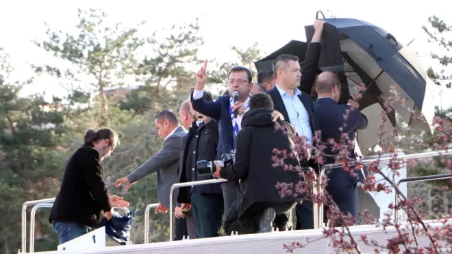 İmamoğlu yağan cisimlerden şemsiye ile korunmaya çalışıldı