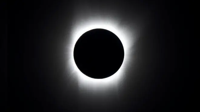 In a total solar eclipse, the Sun is completely covered by the Moon and only a white halo can be seen around the black disc