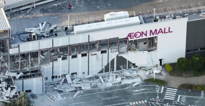 Aeon Mall yazan bir yapının kısmen yıkıldığı görülüyor. Fotoğraf havadan çekilmiş ve yatay yapıda büyük hasar var.