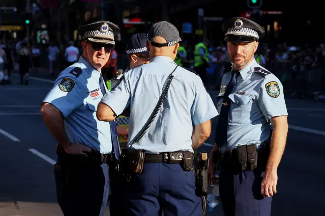 四名身穿制服的警员在街上，其中两人望向镜头。