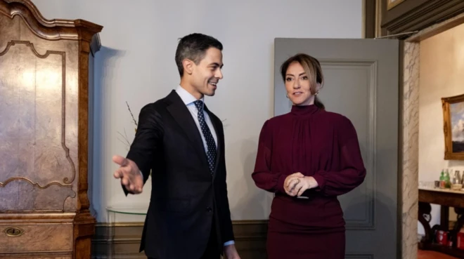 Bir erkek siyasetçi Dilan Yeşilgöz'ü kabul eder şekilde eliyle nazik şekilde buyur ediyor.