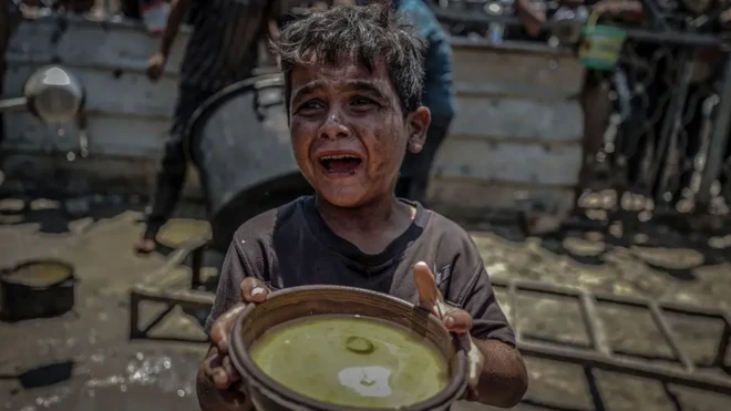 کودکی گریان در حالی که ظرف غذایی را در دست گرفته