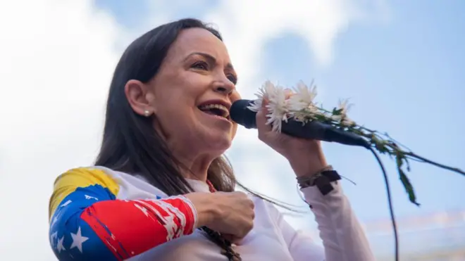 María Corina Machado sosteniendo un micrófono