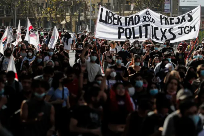 Pessoas carregam faixanumero da pixbetmanifestação com o texto "Libertad a lxs presxs políticxs" 