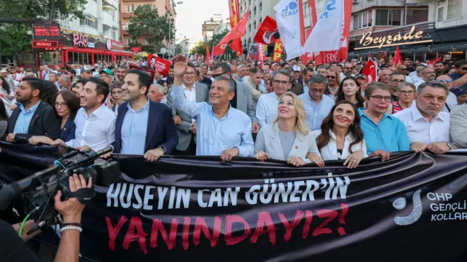 Özgür Özel, Çankaya Belediye Başkanı Hüseyin Can Güner'in gözaltına alınmasının ardından binlerce vatandaşla birlikte Ankara Kuğulu Park'tan Çankaya Belediyesi'ne yürüdü. Ellerinde "Hüseyin Can Güner'in yanındayız" yazılı bir pankart var. 