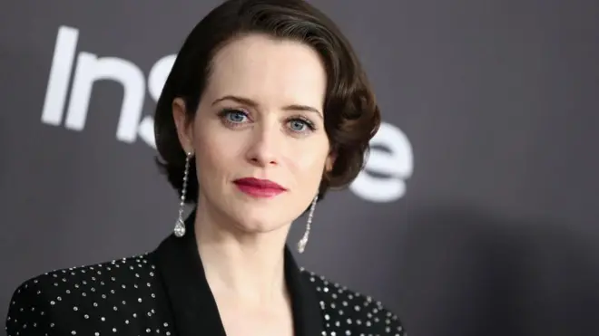 Портрет актриси на сірому фоні в чорному піджаку з блискітками та довгими сріблястими сережками