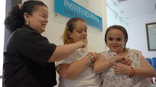 Mujeres con sindrome de laron que se abrazan en un consultorio medico. 