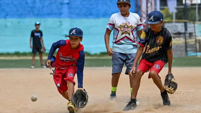 Niños jugando béisbol en un campo de la urbanización 23 de enero de Caracas.