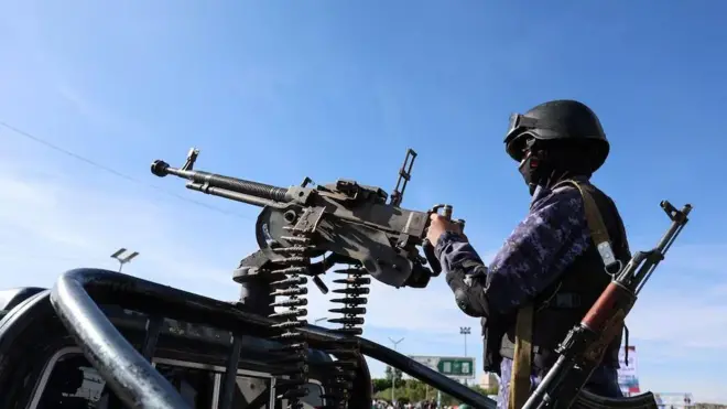 Umupolisi w'umu-Houthi afashe ku mbunda nini ya 'machine gun' imanitse ku modoka y'irondo, ahabera imyigaragambyo yo kwifatanya na Irani, mu gihe intambara y'Amerika-Israel na Irani ikomeje. Ifoto yafotorewe i Sanaa, mu murwa mukuru wa Yemen, ku itariki ya 27 Werurwe (3) mu mwaka wa 2026.