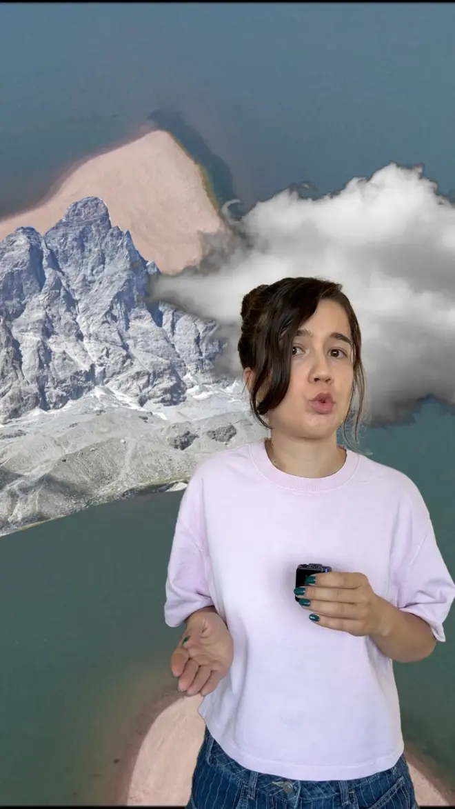 Reporterka gleda u kameru, iza nje se vidi niski vodostaj Dunava, Alpi i oblak.