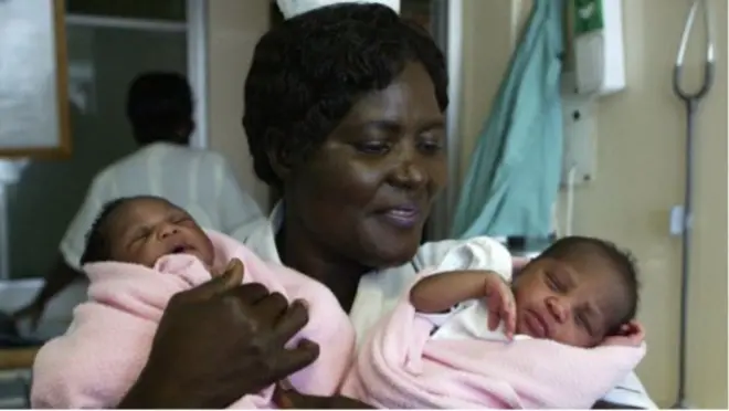 Une infirmière avec deux enfants dans les bras