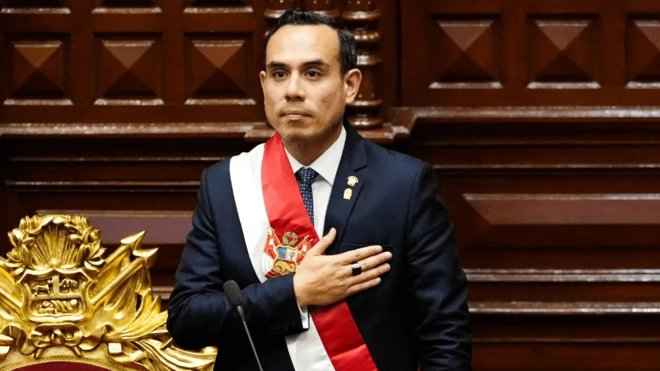 José Jerí con la banda presidencial y rostro serio se lleva la mano al pecho durante el juramento del nuevo cargo.