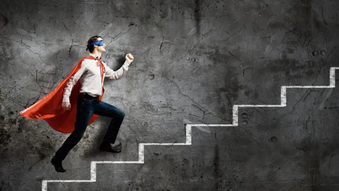 Un homme vêtu d'une cape de héros monte un escalier