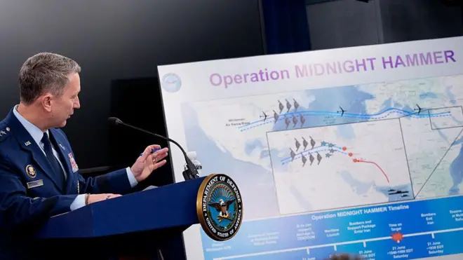 The Chairman of the Joint Chiefs of Staff of the US Air Force Gen Dan Caine discusses the mission details of a strike on Iran during a news conference at the Pentagon. He is standing in front of a large board with images of jets and their flight paths