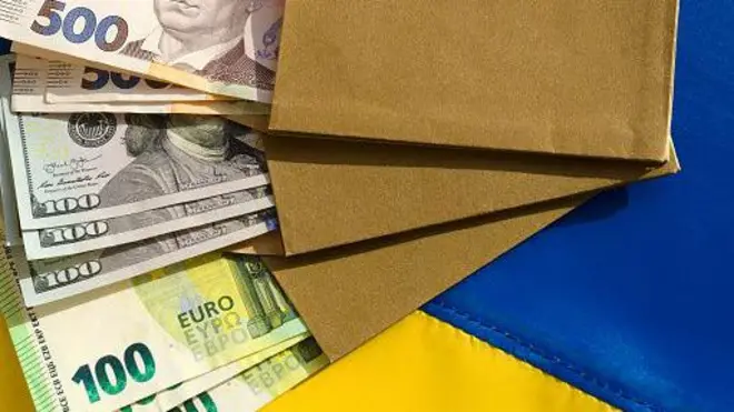 гривні, долари, євро на тлі українського прапора