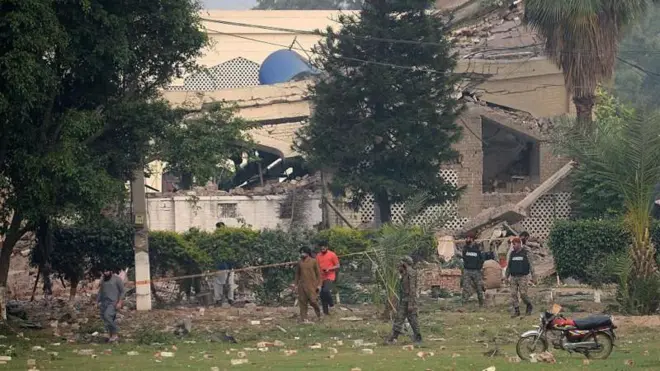 Yıkılan bir bina etrafında askerler