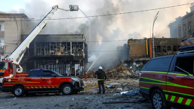 Firefighters work at the site of a Russian drone and missile strike in Kyiv.