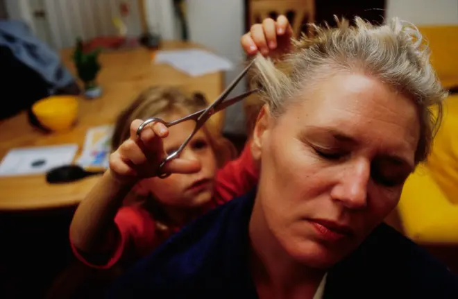 Annesinin saçını kesen bir çocuk