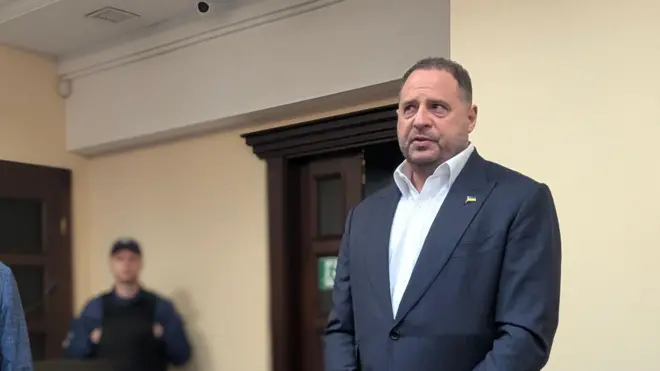 Андрій Єрмак у сірому костюмі і білій сорочці дивиться у бік