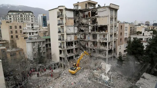 نیروهای امدادی در حال آواربرداری ساختمانی در خیابان اندرزگو تهران که در حمله آمریکا تخریب شده است