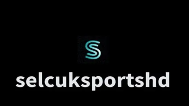 Selcuksportshd yazısı siayh fonda beyaz, tepede S logosu var. 